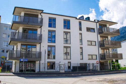 a white building with balconies on a street at myQuartier City Chalets in Innsbruck