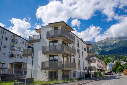 a building with balconies on the side of a street at myQuartier City Chalets in Innsbruck