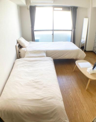 a room with two beds and a table and a window at Free bike and free WIFI 304 Take it easy in Kyoto