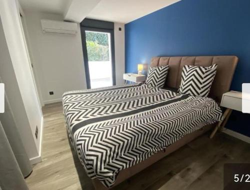 une chambre avec un lit avec une couette noire et blanche dans l'établissement Appartement vue mer piscine, à La Teste-de-Buch