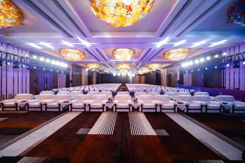 a banquet hall with white chairs and a stage at Crowne Plaza Shanghai Anting-Auto City - 15 Minutes drive to F1 in Jiading