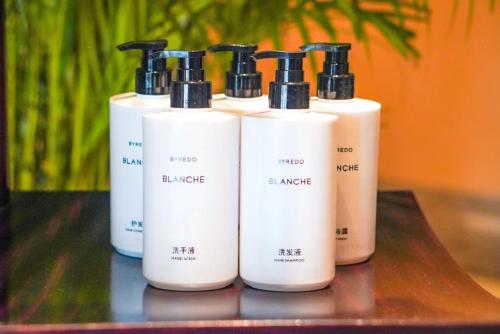 a group of four white bottles sitting on a table at InterContinental Wuxi by IHG in Wuxi