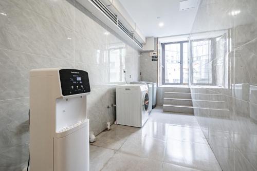 a bathroom with a washer and dryer in a room at Denpa Inn - The Bund East Nanjing Road in Shanghai