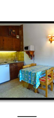 - une cuisine avec une table, une cuisinière et un évier dans l'établissement Studio Montagne, à Taninges