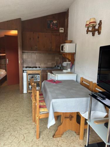 une cuisine avec une table et une cuisine avec une cuisinière dans l'établissement Studio Montagne, à Taninges