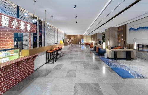 a lobby of a hotel with tables and chairs at The Qube Hotel Anqing in Anqing