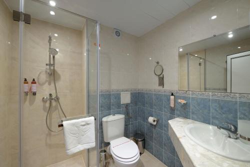 a bathroom with a shower and a toilet and a sink at Aphrodite Beach Hotel in Nesebar