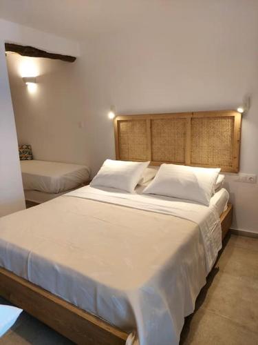 a bedroom with a large bed with white sheets and pillows at Krodoma house 1 in Ios Chora