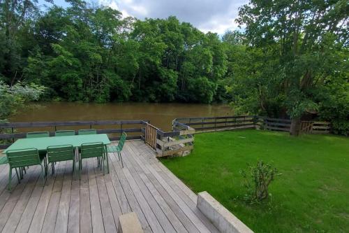 une table et des chaises sur une terrasse à côté d'une rivière dans l'établissement River house with 3 bedrooms, à Montigny-sur-Loing