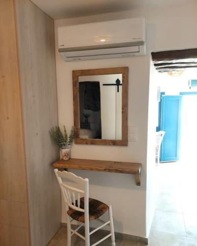 a mirror and a white chair in a room at Krodoma house 1 in Ios Chora