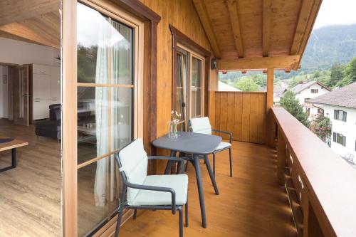 a room with a balcony with a table and chairs at Ferienwohnung Bergspitz in Grainau