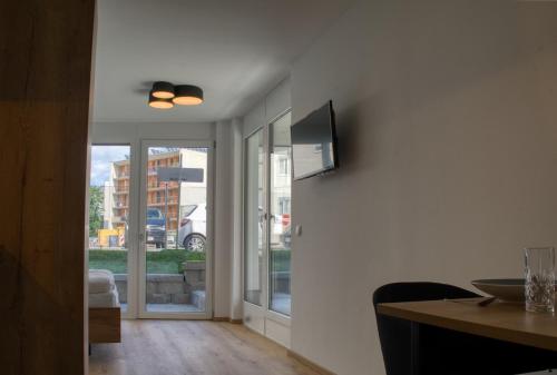 a living room with a table and a television on a wall at myQuartier City Chalets in Innsbruck