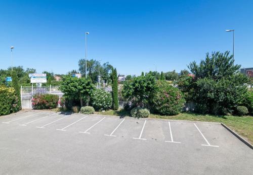 a parking lot with an empty parking lot at B&B HOTEL Avignon 1 in Le Pontet