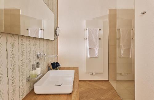 a bathroom with a white sink and a mirror at Lieperts Cafe Dinner Rooms Boutiqe-Zimmer Südsteiermark in Leutschach