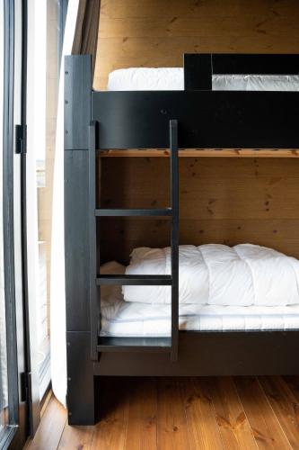 two bunk beds in a room with a wooden floor at The Riverside Mountain Lodge - 110sqm clam luxury - including bed linens, towels, in Idre