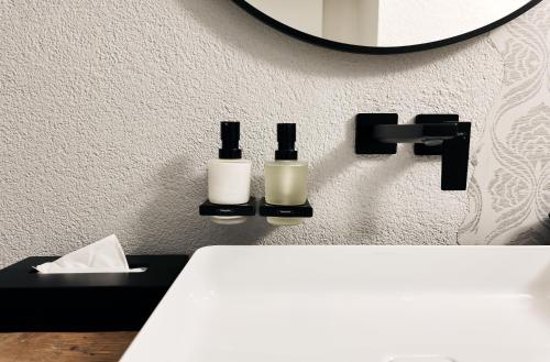 a bathroom with two bottles on a wall at Lieperts Cafe Dinner Rooms Boutiqe-Zimmer Südsteiermark in Leutschach