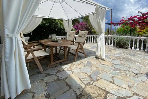 a table and chairs under an umbrella on a patio at Green and Blue View in Elliniká