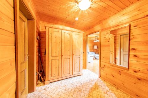 a hallway in a wooden cabin with wooden walls and doors at Ferienhaus Frankenglueck in Egloffstein