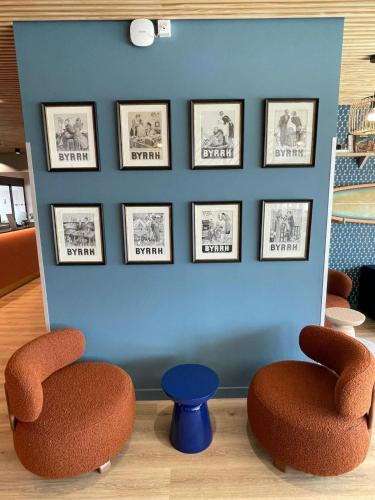 a room with two chairs and pictures on the wall at Kyriad Limoges - Ester in Limoges