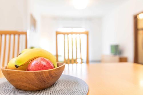 a wooden bowl of fruit on a table at Ferienhaus Frankenglueck in Egloffstein