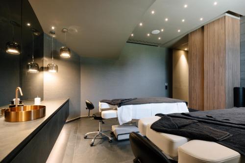 a bedroom with a bed and a desk and a sink at Paros Agnanti Resort & Spa in Parikia