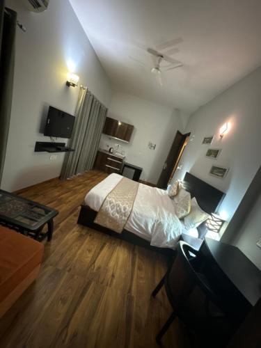 a bedroom with a bed and a living room at Pearl suites at Omaxe entrenity in Vrindāvan