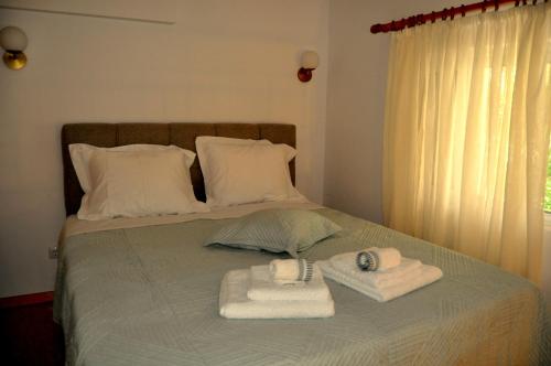 a bed with two towels and pillows on it at MagnoliaHouse 2 in Preveza
