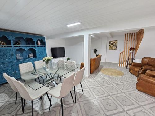 a dining room with a glass table and white chairs at Funchal Infinity View House by Rentallido in Funchal