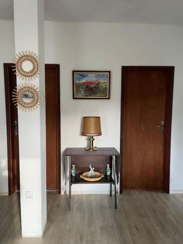 a room with a table with a lamp and a door at Idylle in der Natur mit Burgblick in Sutomore