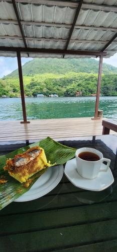 Una mesa con un plato de comida y una taza de café. en Delfika 2 Guest House, en Bandanaira