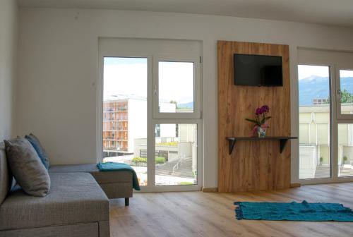 a living room with a couch and a flat screen tv at myQuartier City Chalets in Innsbruck