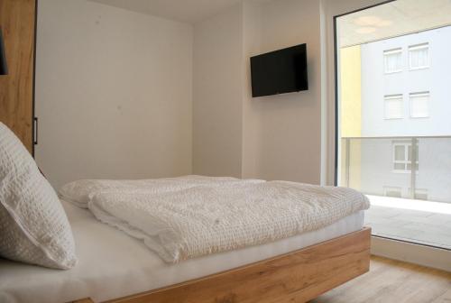 a bedroom with a bed and a tv on the wall at myQuartier City Chalets in Innsbruck