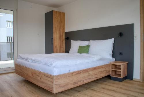 a bedroom with a large bed with a wooden headboard at myQuartier City Chalets in Innsbruck