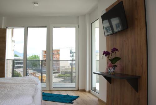 a bedroom with a bed and a television on a wall at myQuartier City Chalets in Innsbruck