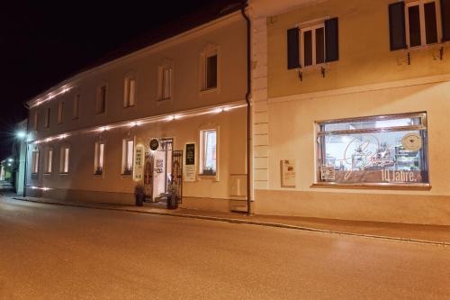 a building on the side of a street at night at Lieperts Cafe Dinner Rooms Boutiqe-Zimmer Südsteiermark in Leutschach