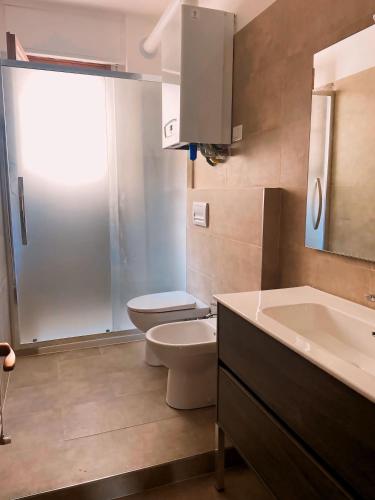 a bathroom with a toilet and a sink at Casa Caletta - Appartamento con piscina a 100metri dal mare in Castiglioncello