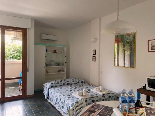 a small bedroom with a bed and a table with water bottles at Appartamento con piscina a 100metri dal mare in Castiglioncello