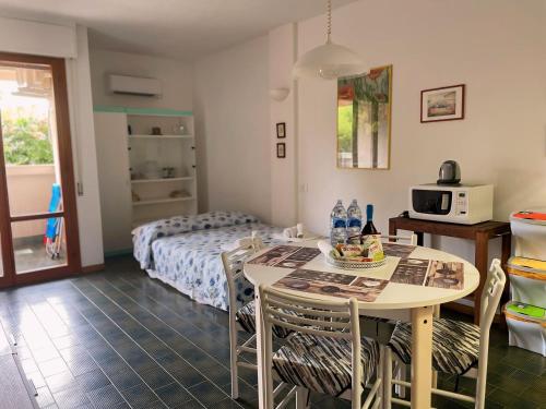a room with a bed and a table with chairs at Appartamento con piscina a 100metri dal mare in Castiglioncello