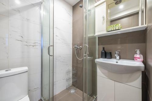 une salle de bain avec une douche en verre et un lavabo dans l'établissement zen intimate in exarcheia, à Athènes