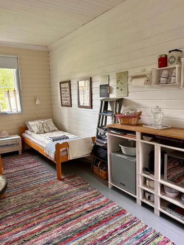 a small room with a bed and a rug at Savikulma B&B in Mynämäki
