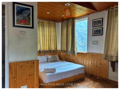a bedroom with a bed in a room with a window at Himalayan Abode Joshimath in Joshīmath