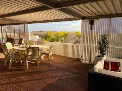 Nectar BrookSpear Creek Beach House的露台上有一张桌子和几把椅子