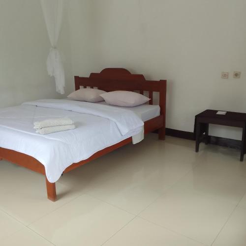 a bedroom with two beds and a side table at Shila Bungalow in Kelimutu