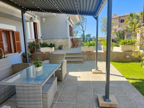 a patio with a table and chairs under an umbrella at Villa Capllonch in Banyalbufar