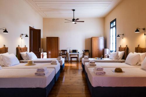 a room with four beds with towels on them at Sundial Lodge in Chania