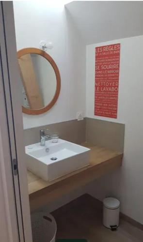 une salle de bain avec un lavabo blanc et un miroir dans l'établissement Maison accueillante avec vue sur la mer à Saint-Philibert, à Saint-Philibert