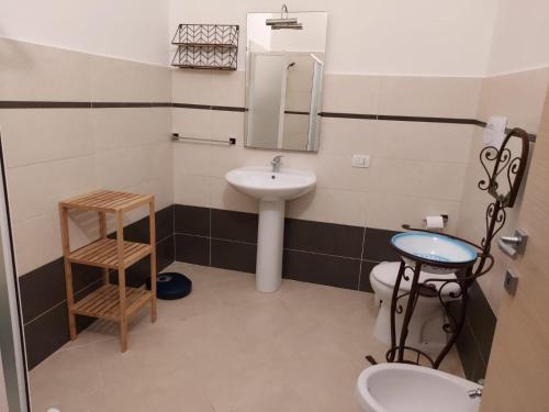 a bathroom with a sink and a toilet and a mirror at La Perla al mare 300mt from Perla Marina Beach in Santa Margherita di Pula