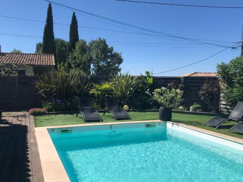 - une piscine avec 2 chaises à côté d'une cour dans l'établissement les costebelles, à Valensole