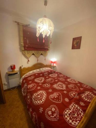 - une chambre avec un lit doté d'un couvre-lit rouge et blanc dans l'établissement Areches Village, à Arêches