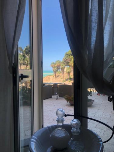 a glass sink in front of a window with a view of the ocean at Casa Veranda sul mare in Gela